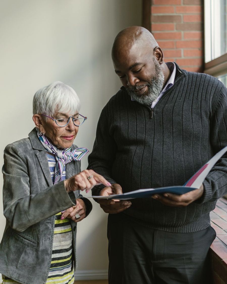 An adviser and a client reviewing a document together by a window